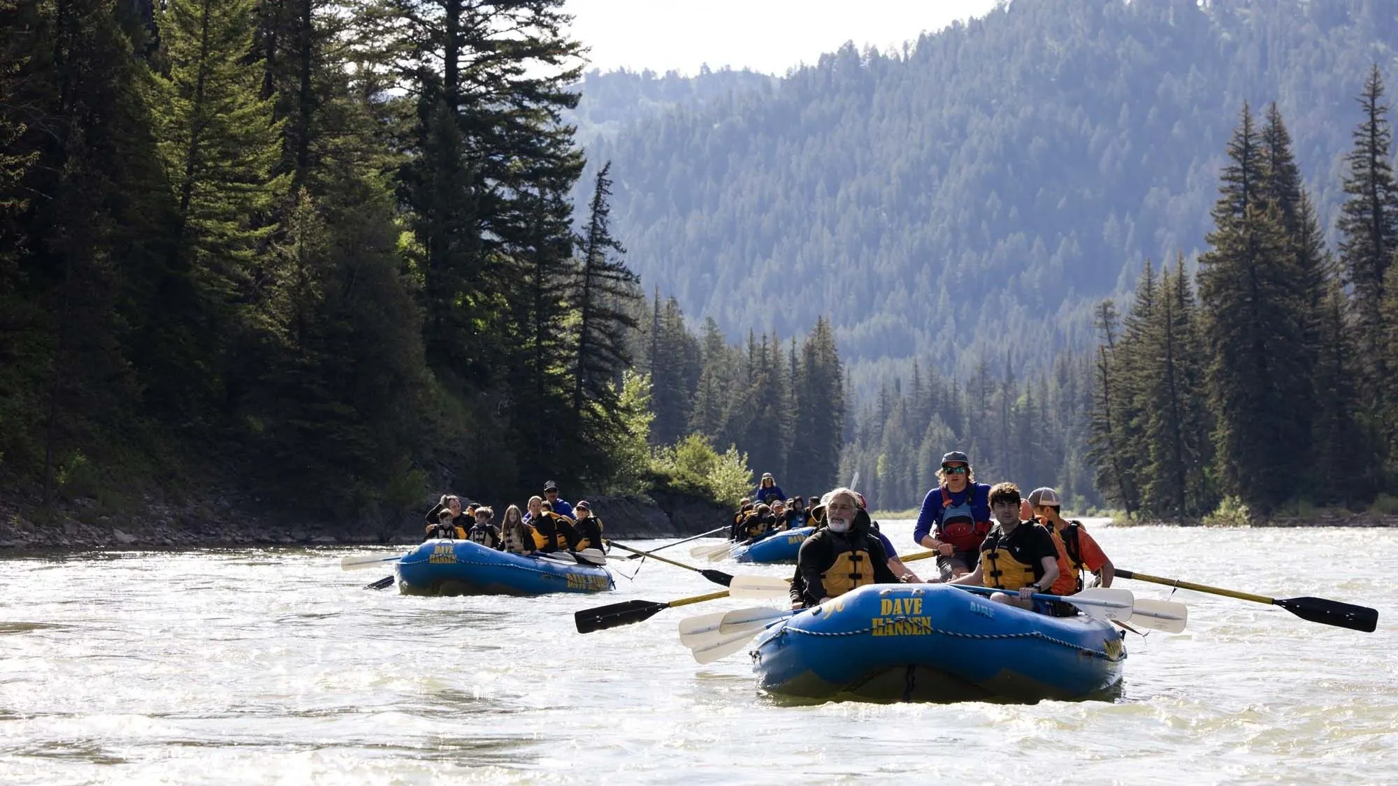 Three blue Dave Hansen Whitewater Rafts take a moment to relax on the Snake RIver.