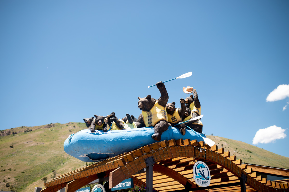 A sculture of bears wearing yellow lifejackets on a blue whitewater raft.