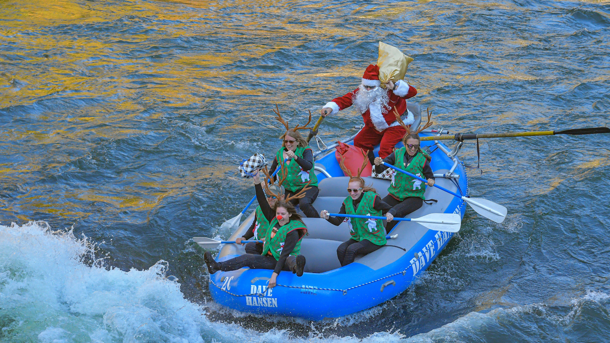 Rafters dressed in Santa and reindeer costumes ride through a whitewater rapid on the Snake River.