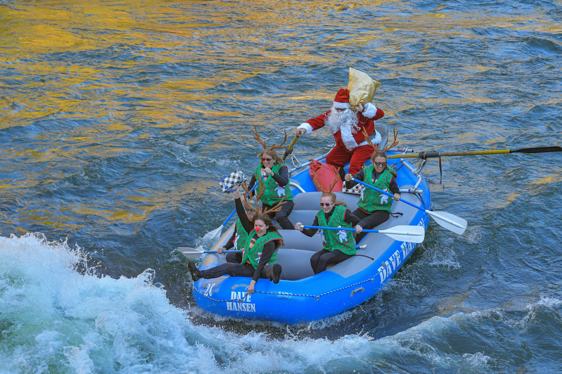 Rafters dressed in Santa and reindeer costumes ride through a whitewater rapid on the Snake River.